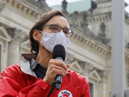 Volunteer wearing a mask and speaking in public