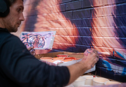 Artist Sonny Sundancer paints a tiger mural 