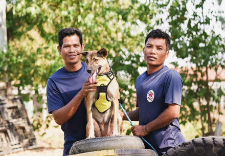 Zwei Mitarbeiter des Tierheims mit einem geretteten Hund 
