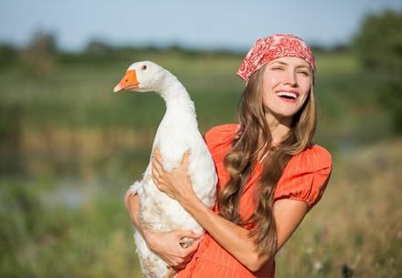 Beautiful woman holds a goose